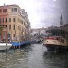 Gondolas on the left, a Vaporetto on the right, with the Rialto Bridge in the distance.