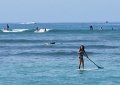 A view of some of the surfers and swimmers.  Note the girl on the paddle board.