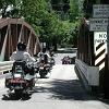 A group of motorcyclists cross the bridge