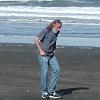 Bill takes off his shoes to go walk in the Pacific. - Note the cruise ship on the horizon in the background.