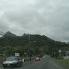 The road goes through small towns and past mountains.