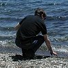 Larry investigates the white lava rocks (pumice) - which were light enough that they floated in the lake!